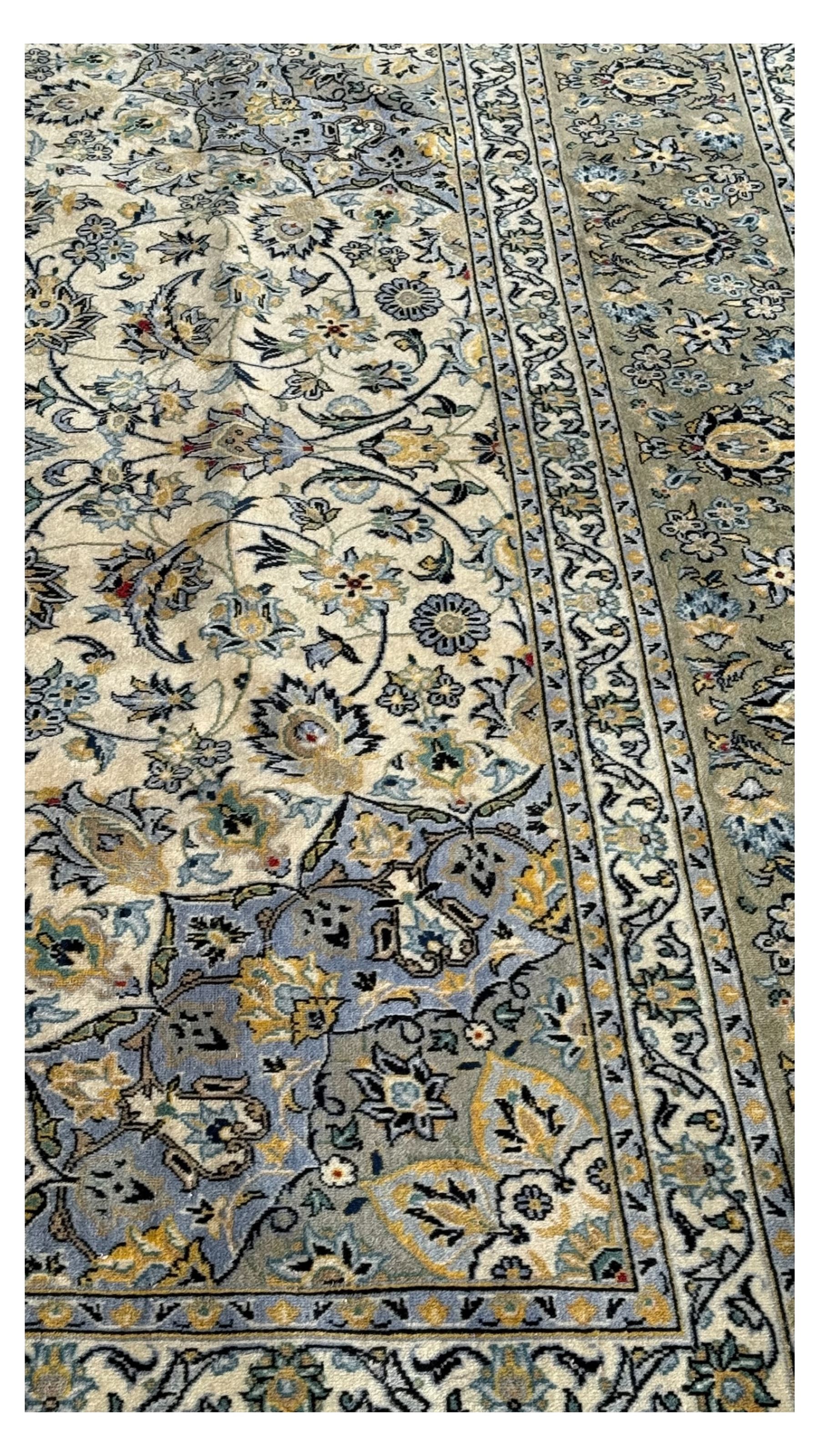Kashan Persian rug, hand knotted, ivory ground rug, the rosette medallion decorated with projecting palmettes, on a field of swirling leafy branches and decorated with further palmettes, the scrolling border with repeating stylised plant motifs, within floral pattern guard stripes