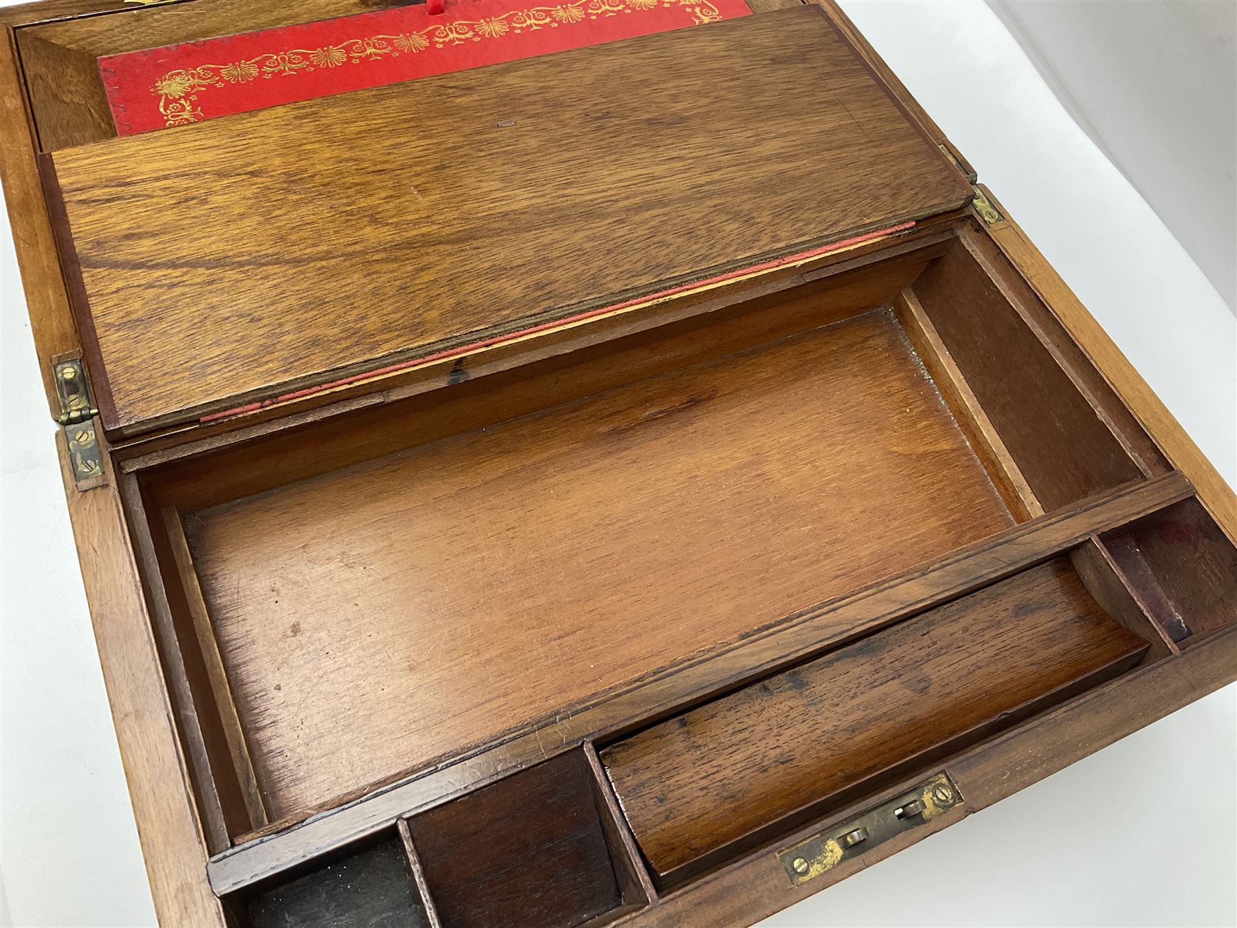 19th century burr yew wood tea caddy, of sarcophagus form, with strung details and brass mounts, the interior split into three compartments, upon four brass bun feet, together with an oak and brass bound writing slope, with red leather interior with gilt detailing, largest H16cm, W40cm