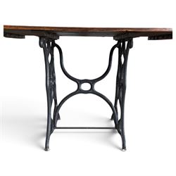 Antique rectangular slatted hardwood garden table, raised on pierced black painted cast iron supports cast with scrolling branchwork and united by pierced curved X-stretcher