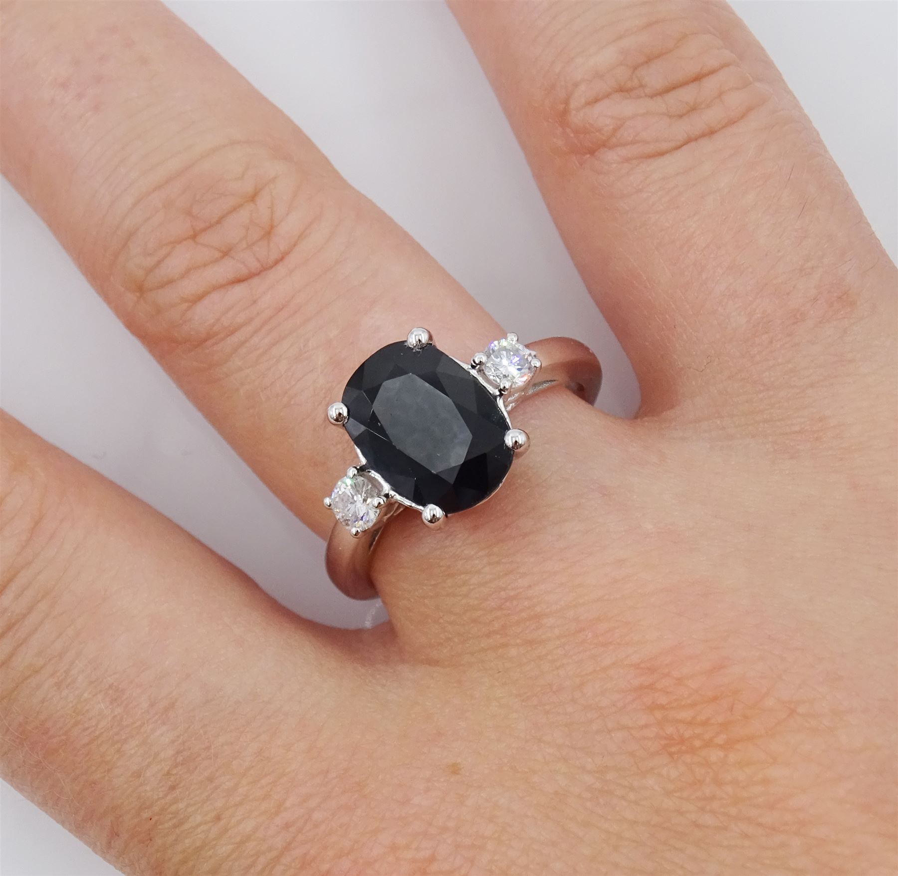 18ct white gold sapphire and diamond three stone ring, single oval cut sapphire of approx 3.00 carat, with a round brilliant cut diamond set either side, hallmarked, total diamond weight approx 0.25 carat