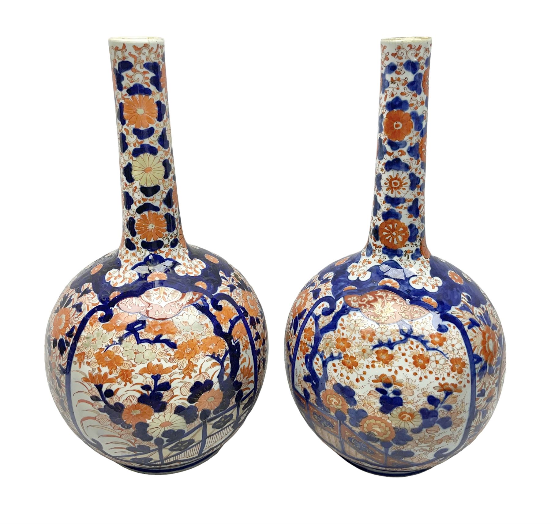 Pair of large 19th century Japanese Imari porcelain bottle vases, painted with shaped reserves of peonies, chrysanthemums and prunus blossom, each H46cm