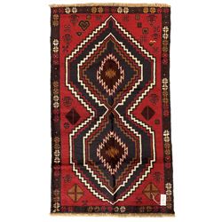 Baluchi red and blue ground rug decorated with two geometric lozenges and a repeating border