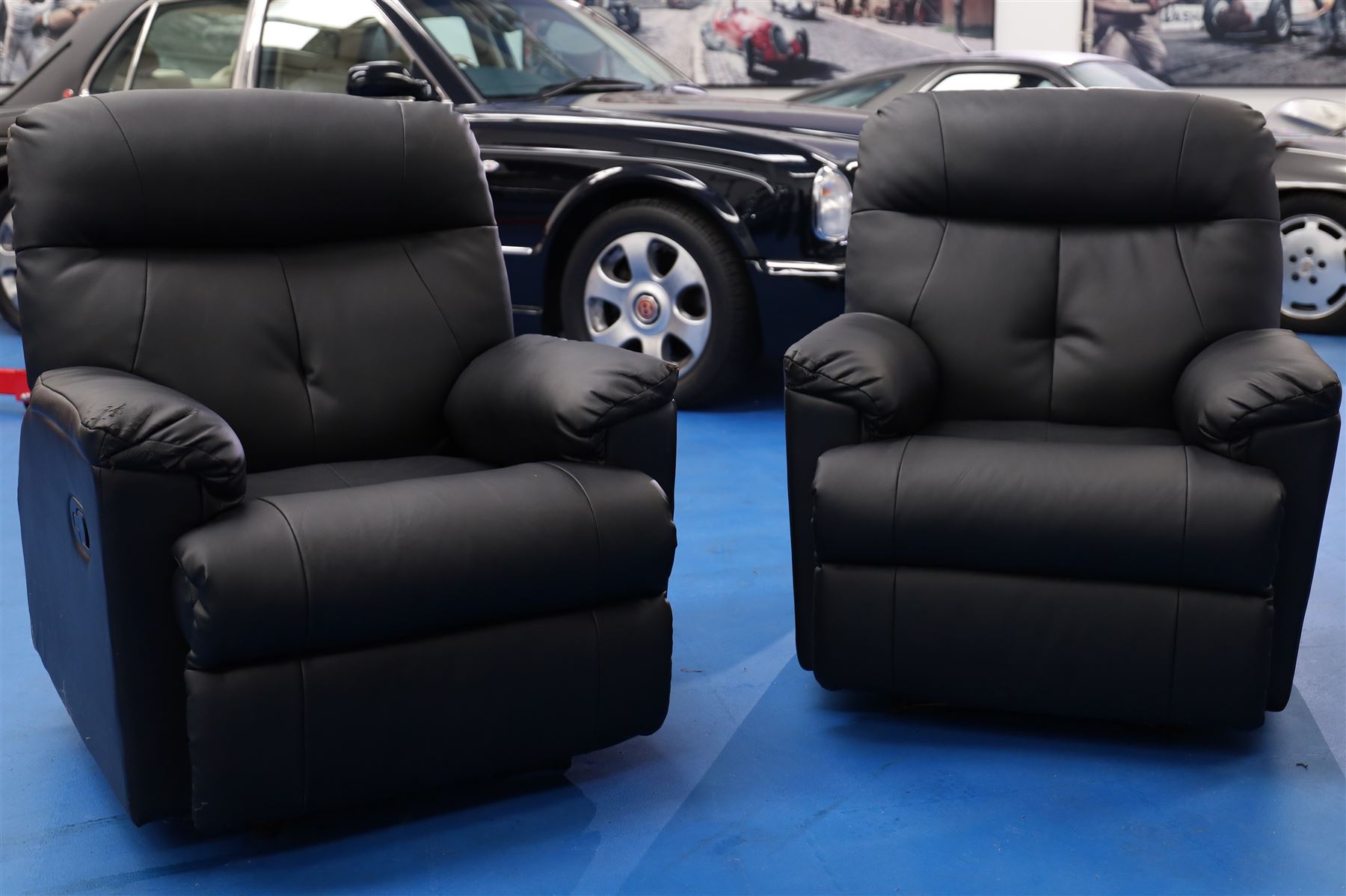 Two reclining armchairs upholstered in black faux leather
