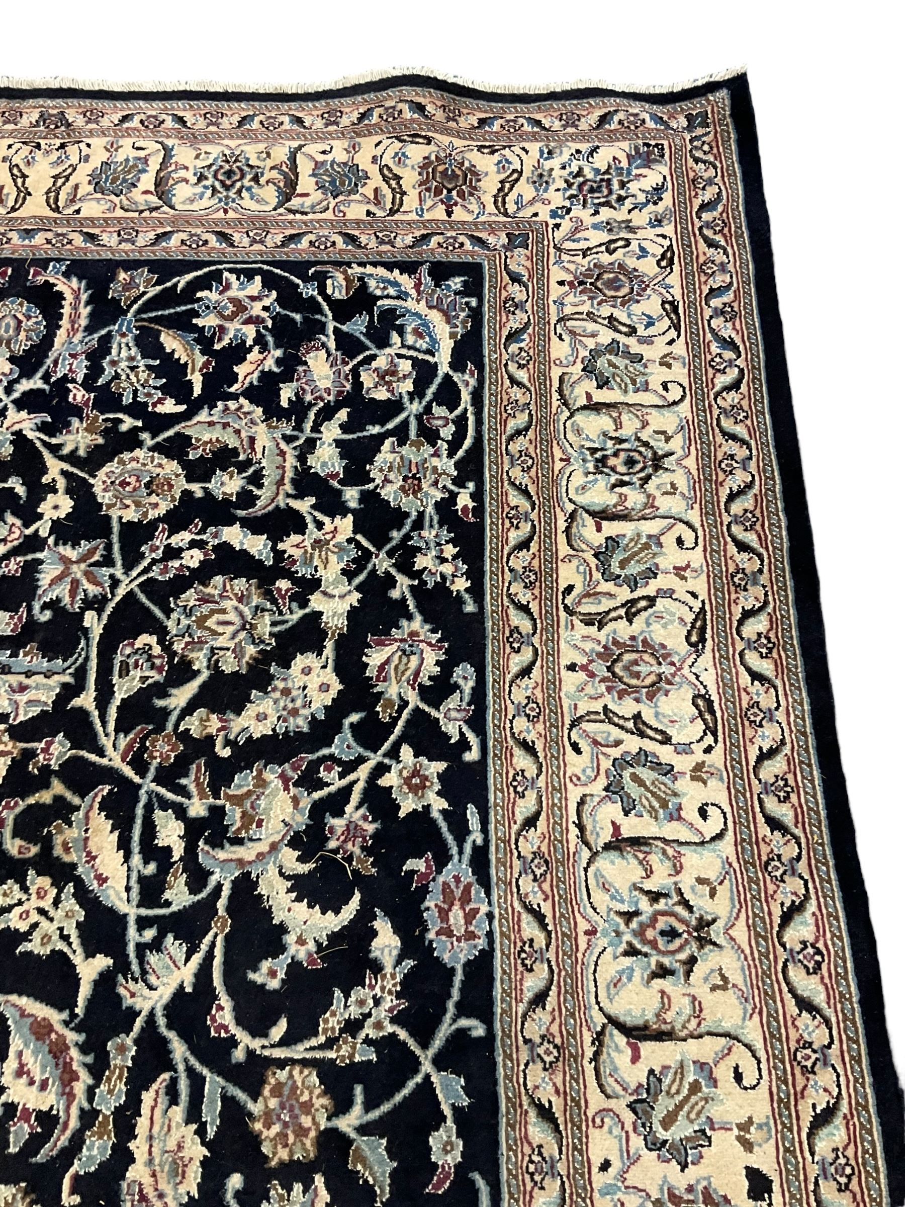 Central Persian part silk indigo ground Nain carpet, the field decorated with interlacing leafy branches and stylised plant motifs, scrolling design border within guard stripes 