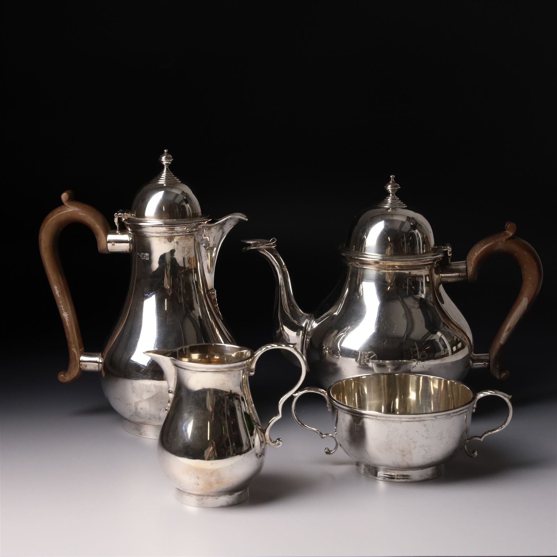 Four piece silver tea and coffee service of baluster form, the tea and coffee pots with domed covers and stained handles London 1916-1918, Maker  C S Harris & Sons Ltd