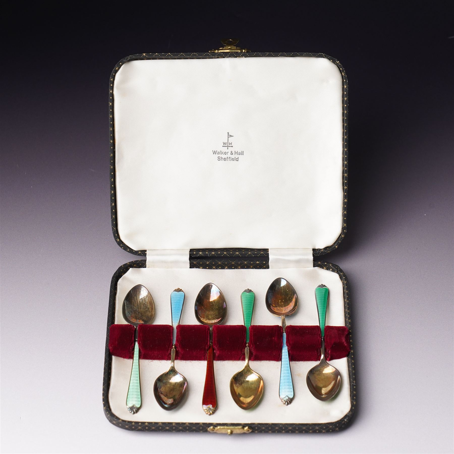 Set of six silver gilt coffee spoons with coloured enamel stems, cased Birmingham 1962 in Walker & Hall case