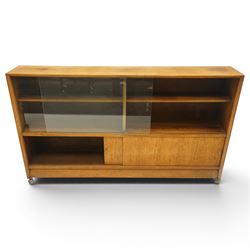 Herbert E Gibbs - Mid 20th century teak bookcase with sliding glazed doors, glazed upper section with adjustable shelf, above to two teak doors, raised on castors