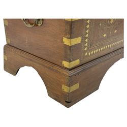 Zanzibar chest, early 20th century, of hardwood construction with brass inlaid foliate and geometric decoration to the lid, fitted interior of multiple carved compartments, with brass strapwork, side handles, and shaped bracket feet