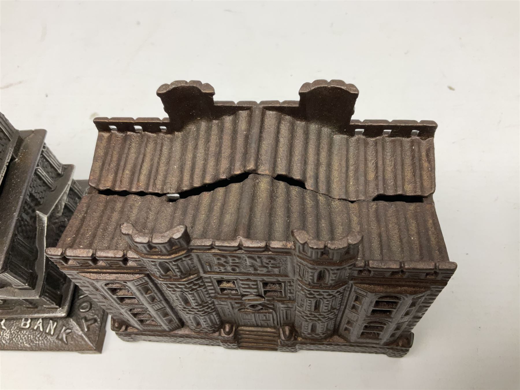 Five early 20th century cast-iron money banks as buildings - 'City Bank' c1904 H10cm; 'County Bank' c1905 H11cm; 'Town Hall Bank' c1900 H8.5cm; 'Tower Bank' c1902 H23.5cm; all made by John Harper; and 'Blackpool Tower Bank' c1907 by Chamberlain & Hill H18.5cm (5)