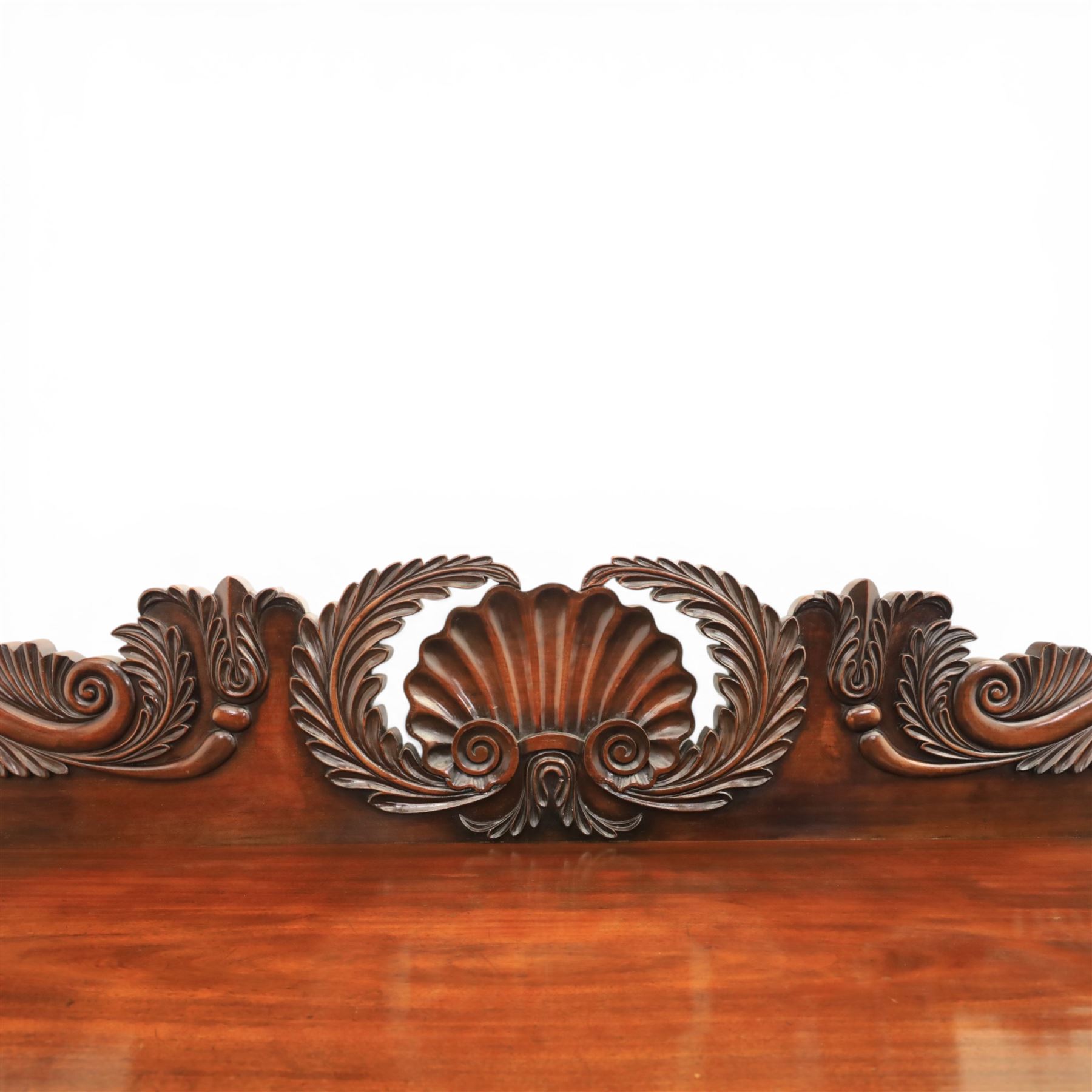 Mid Victorian mahogany pedestal sideboard, the rectangular top with raised back centred by a carved shell within scrolling acanthus and foliate cresting, over a central shaped frieze drawer flanked by two short drawers, above a kneehole recess, flanked by panelled cupboard doors with carved corbel supports, enclosing shelved interiors