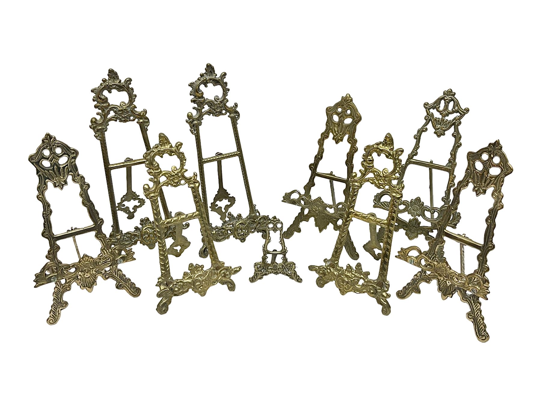 Nine ornate cast brass easel stands of various sizes, H24cm