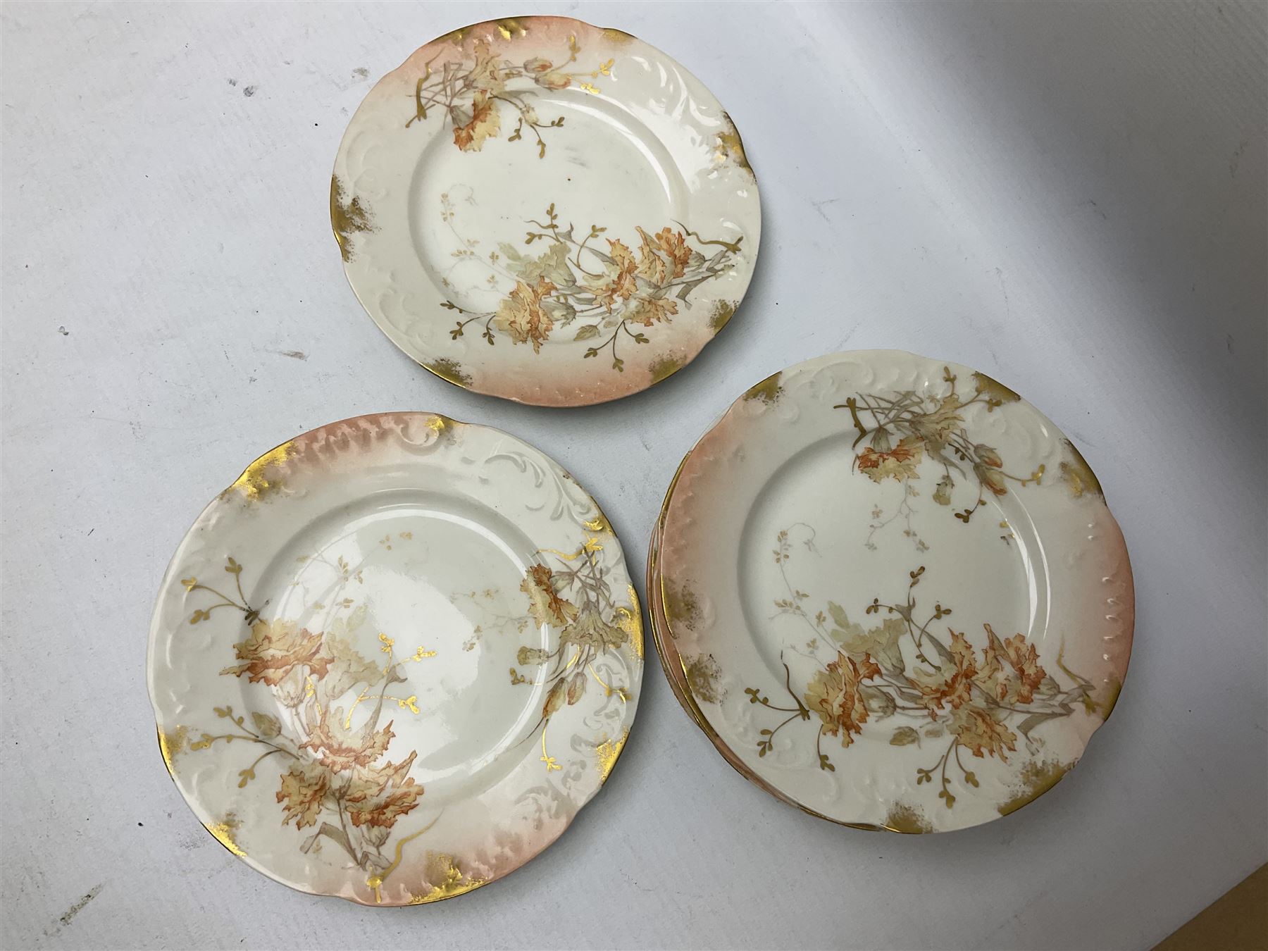 Early 20th century Limoges part tea service, decorated with floral sprays and gilt on merging peach and white ground, comprising six teacups, twelve side plates, six smaller plates, milk jug, open sucrier, slop bowl and two cake plates, many marked R Delinieres Limoges D&C France to base