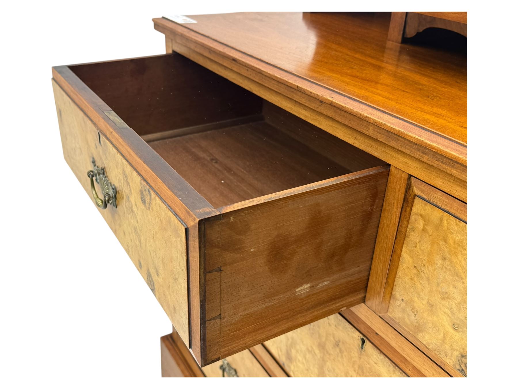 Victorian walnut bedroom suite - wardrobe, dressing chest and bedside cupboard, comprising a full-length wardrobe with broken pediment and central mirrored door, large lower drawer, a matching dressing table with bevelled swing mirror over two trinket drawers and two short drawers over two long drawers, and a single-door bedside cupboard, all with moulded edges, decorative panel work and shaped aprons