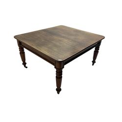 Late 19th century extending mahogany dining table, square top with banded frieze rail, raised on turned octagonal supports with  brass cups and castors, with two additional leaves
