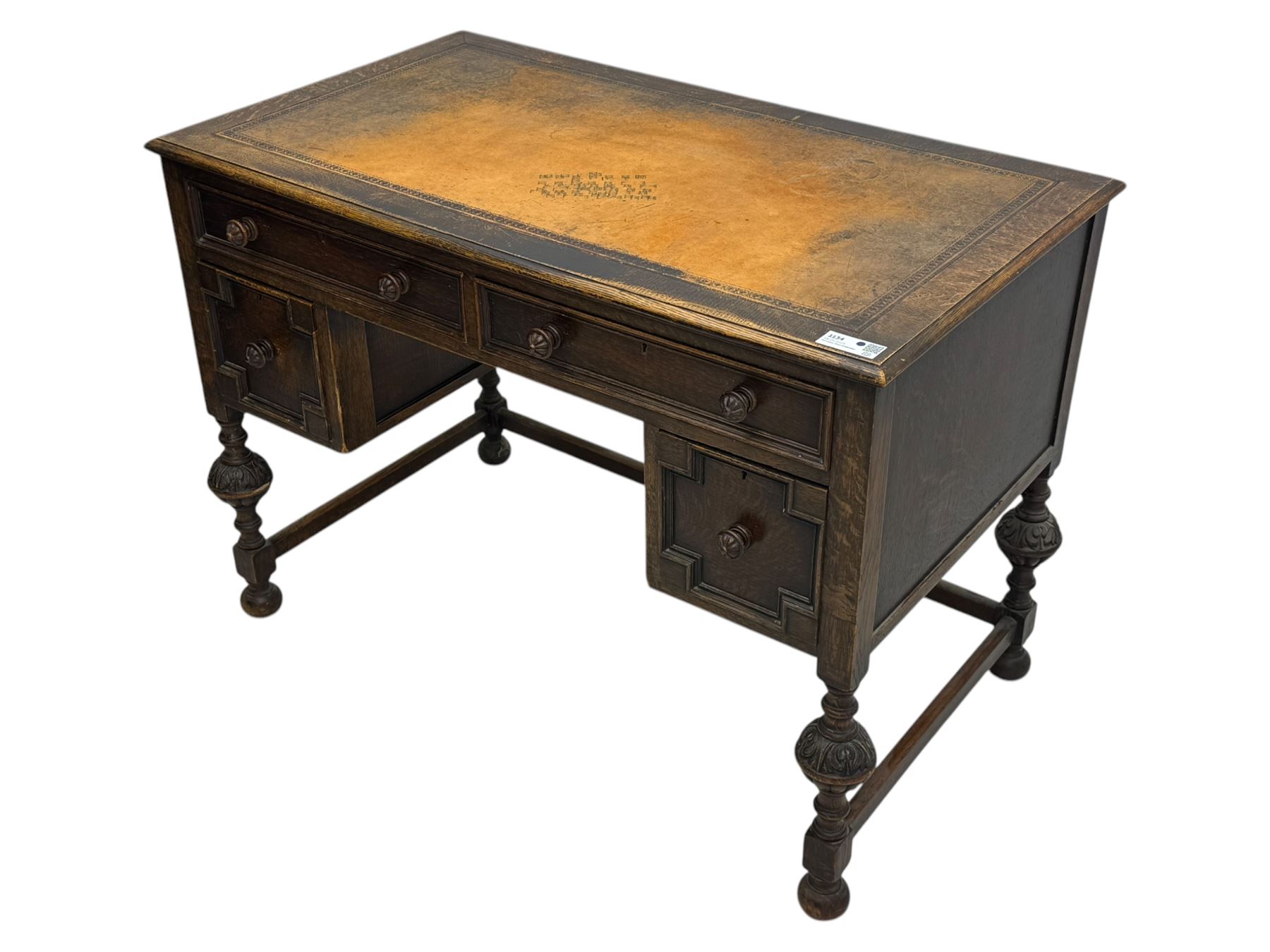 Early 20th century Jacobean design oak desk, with rectangular top inset with worn tooled leather, two frieze drawers over pedestals each fitted with a pair of panelled drawers, turned handles, on carved and fluted tapering legs united by stretchers 