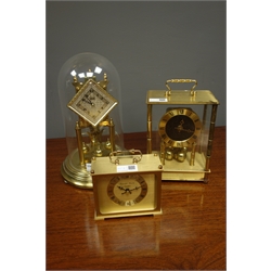  Late 20th century 'Kundo' anniversary torsion clock with lozenge shaped dial, under dome (H29cm), another torsion clock and a quartz clock in polished metal case  
