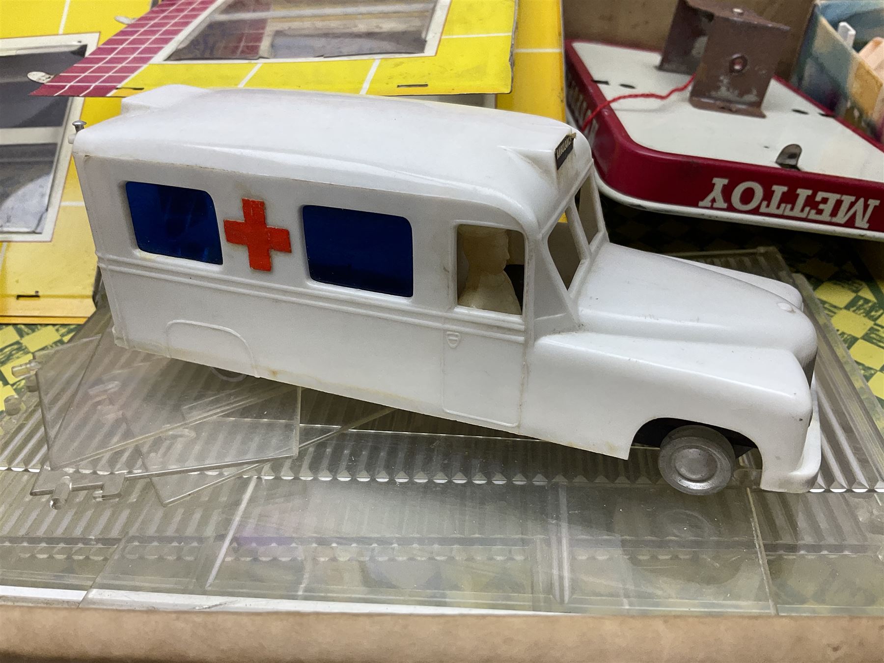 Late 1950s/early 1960s Mettoy tin-plate Emergency Ward 10 hospital set from the TV series, including over twenty figures, over sixty pieces of hospital equipment, beds, chairs, lockers, theatre fittings, stretchers etc; building is complete with movable transparent partitions, operating lift with sliding lift shaft doors and opening windows; wards with fitted swing doors; tin-plate walls with lithographed detail in yellow with red and white tiled effect, cobbled base with ambulance casualties area and lift access; boxed with instructions