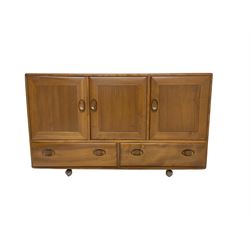 Ercol - light elm sideboard, fitted with three cupboards and two drawers, on castors