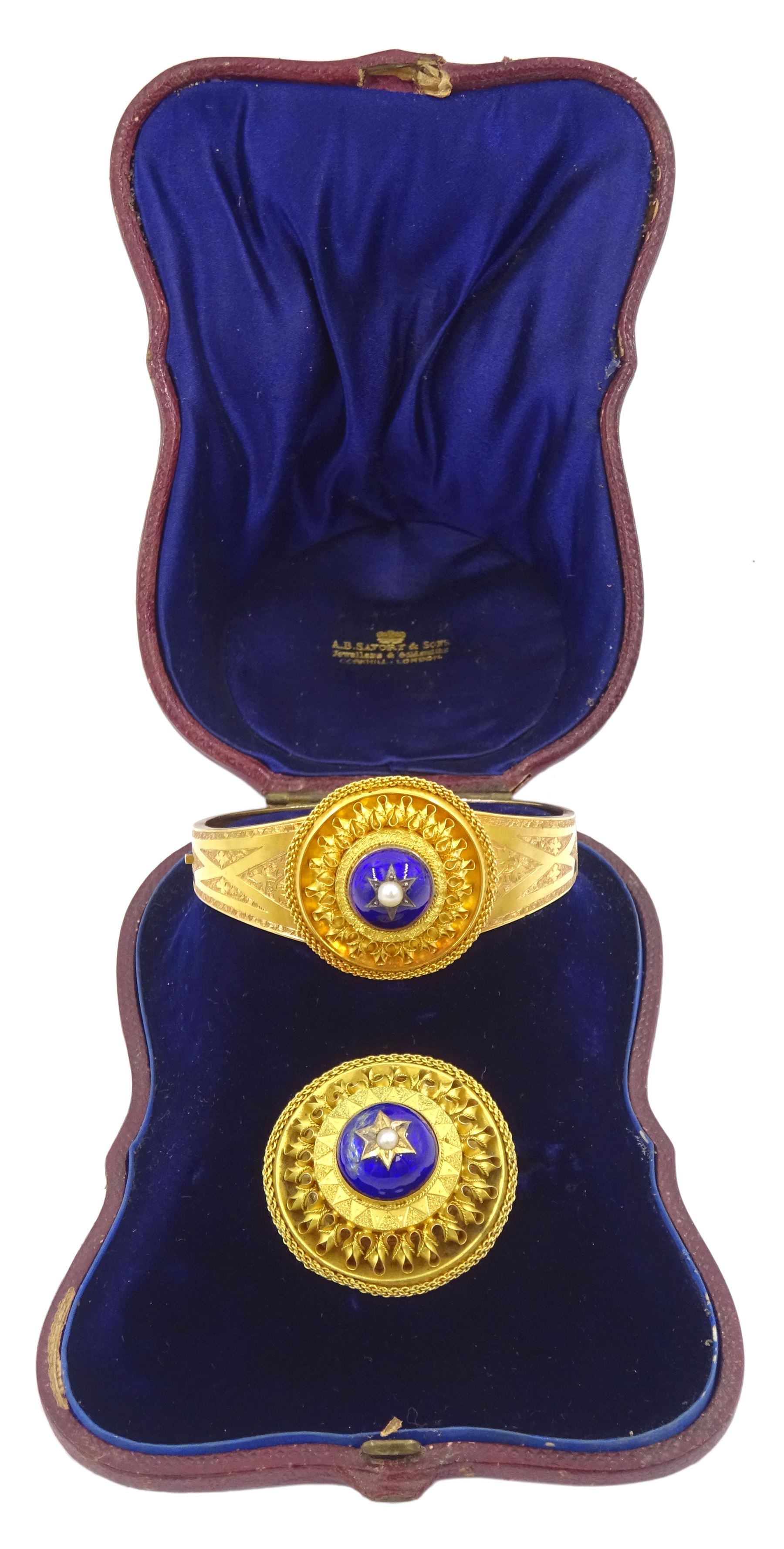 Victorian 18ct gold enamel and seed pearl hinged bangle and matching brooch, each star set with a seed pearl and blue enamel dome within a circular cannetille frame, each with a glazed panel verso, the hinged bangle with foliate engraved decoration, in fitted case