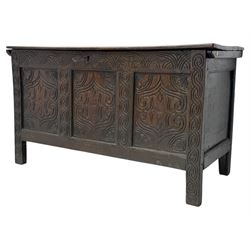 English carved oak coffer, hinged rectangular lid with indented side edges, internal candle-box, front with three-panel front with decorative carvings, raised on stile feet, circa 1700