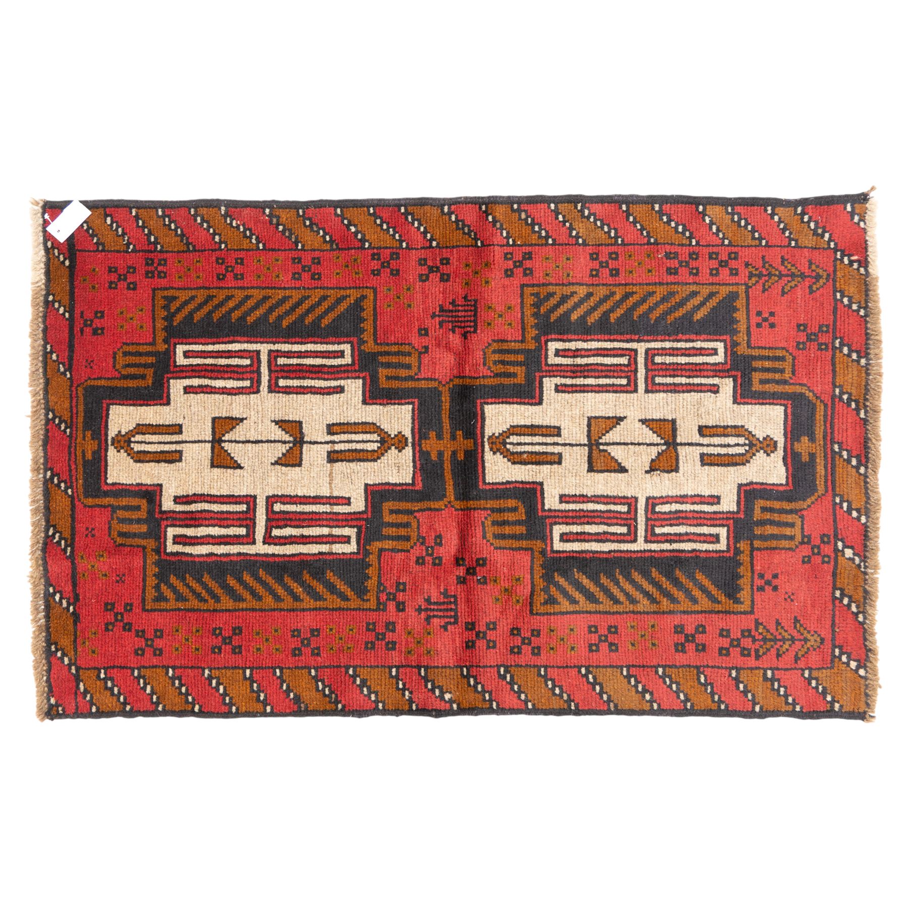 Turkish Anatolian rug, crimson ground, with stepped geometric medallions in ivory, brown, and black within angular striped borders in tones of red and ochre 