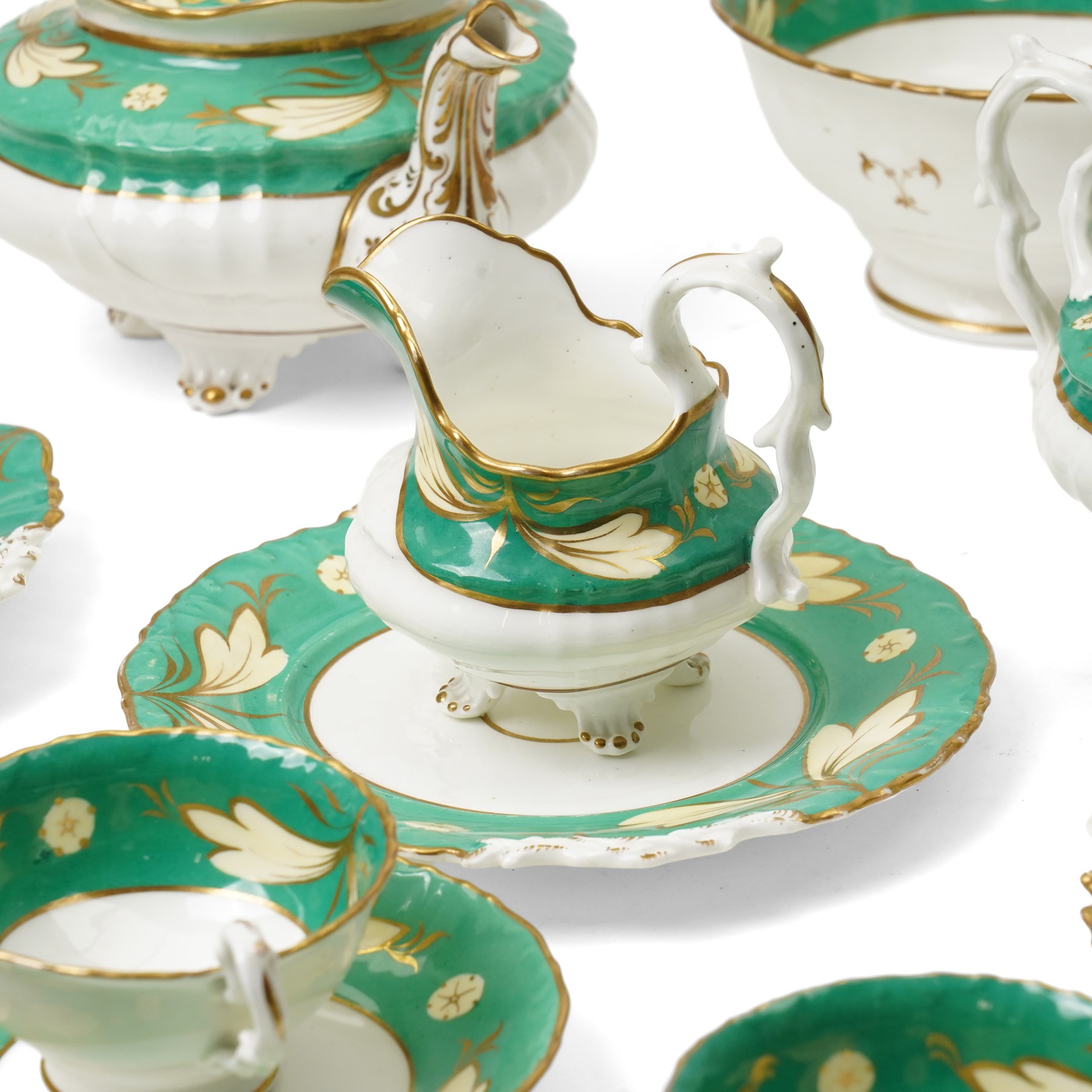 19th century porcelain tea service decorated with a border pattern of yellow leaves on a green ground comprising twelve cups and saucers, tea pot, sucrier and cover, milk jug, slop bowl and three plates, pattern number 5850