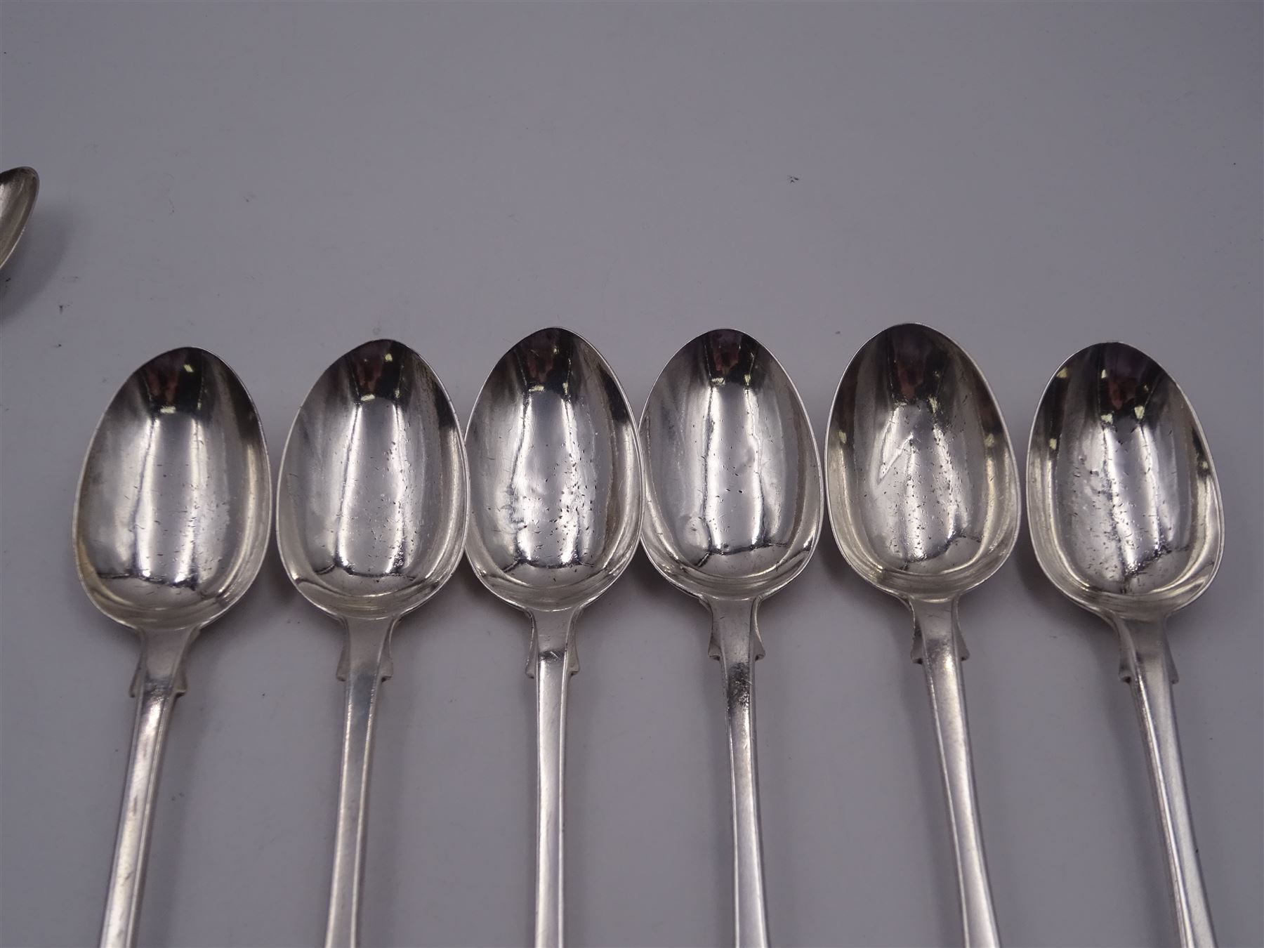 Group of Victorian silver fiddle pattern spoons, comprising pair of sauce ladles and set of six teaspoons, both hallmarked Henry Holland (of Holland, Aldwinckle & Slater), London 1857, set of four table spoons, hallmarked Chawner & Co (George William Adams), London 1857, and set of six dessert spoons, hallmarked Chawner & Co (George William Adams), London 1856, with monogrammed terminals, approximate total silver weight 25.50 ozt (792.6 grams)
