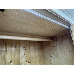 Victorian design lime-washed pine single wardrobe, projecting cornice over panelled door enclosing hanging rail, the lower section fitted with full-width drawer, on shaped plinth base