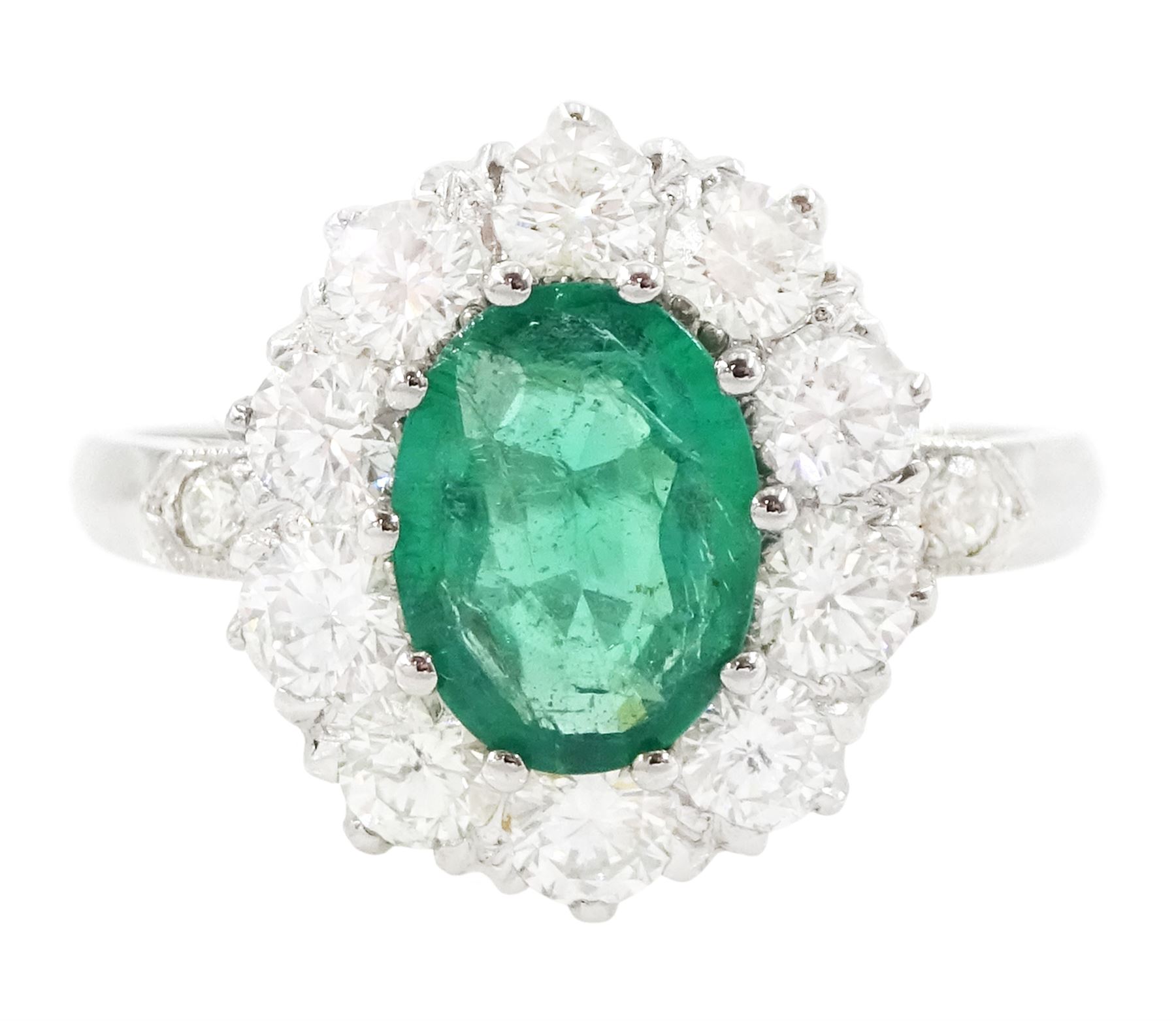 Platinum emerald and diamond cluster ring, single oval cut emerald of approx 0.90 carat, surrounded by ten round brilliant cut diamonds, and milgrain set diamond shoulders, stamped Plat, total diamond weight approx 1.00 carat