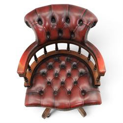Captains swivel desk chair upholstered in oxblood leather, buttoned back and seat, shaped arm bow raised on turned spindles, five spoke base raised on castors