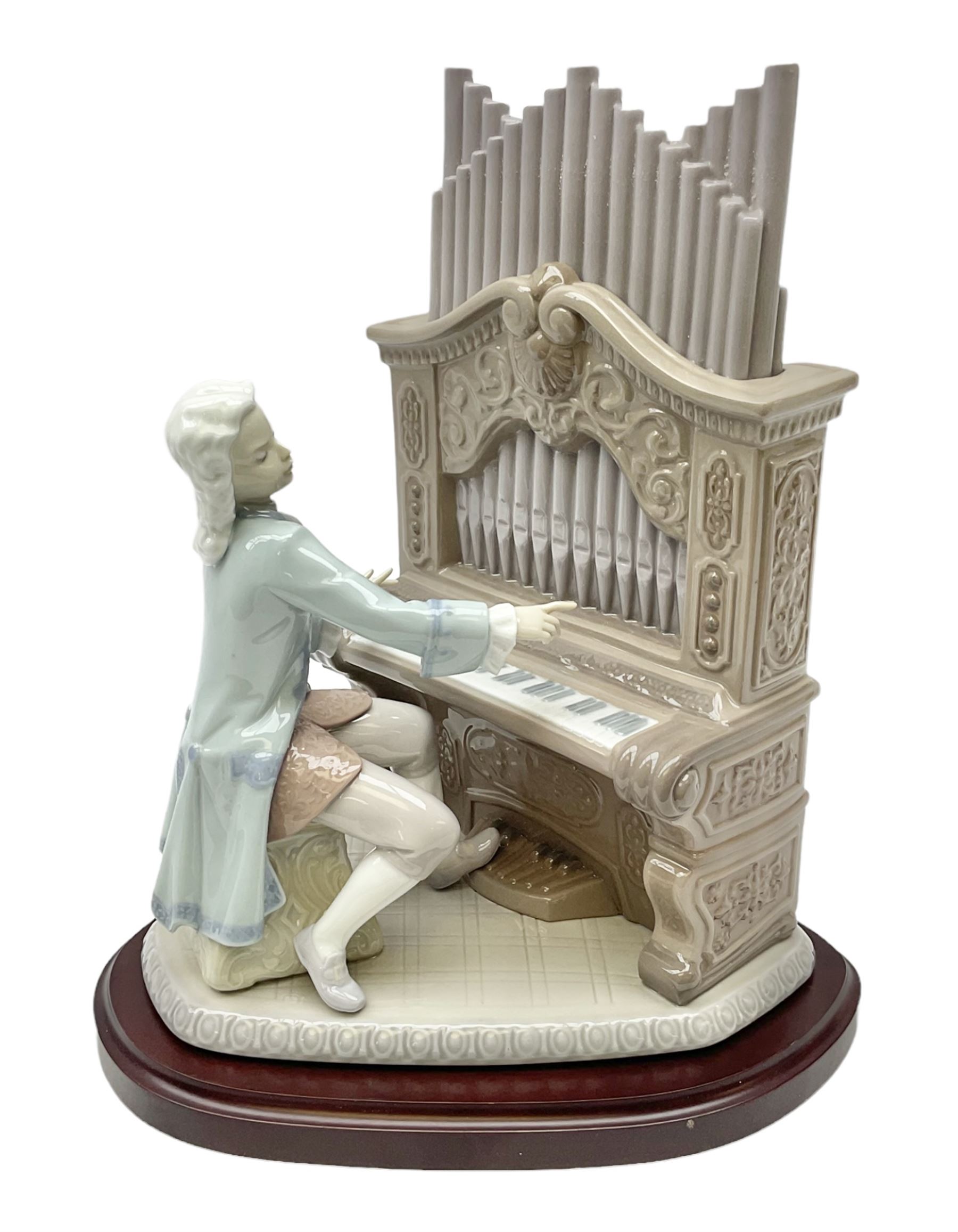 Lladro figure, Young Bach, modelled as a young Johann Sebastian Bach playing the piano, on a mahogany oval base, limited edition 2348/2500, in original box, no 1801, year issued 1994, year retired 1995, H29cm