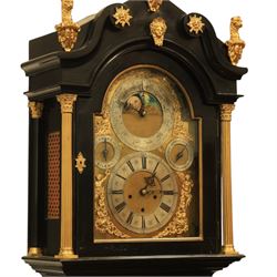 Late nineteenth century ebonised and gilt-bronze mounted musical longcase clock of impressive architectural form, the case of ebonised finish with applied gilt bronze neoclassical inspired masks and mounts, hood of arched form with glazed door, flanked by free fluted columns with gilt bronze Corinthian capitals surmounted by stylized Lion finials, frieze and arch enriched with applied foliate mounts, trunk with a rectangular glazed door bordered by mouldings and flanked by engaged columns with gilt bronze mounts above a shaped projecting base panel with applied central female mask and corner foliate ornamentation, arched brass dial, with a silvered chapter ring and applied cast gilt bronze spandrels and arch decoration, incorporating subsidiary selection dials for chime/silent and tune regulation, offering Cambridge chimes on eight bells and an additional chime sequence on ten bells, brass arch is further embellished with a moon phase aperture with lunar calendar scale, Zodiac symbols, month and date indication on a silvered dial, substantial eight-day, three-train movement with pinned cylinder musical train and a graduated nest of eleven bells with eleven hammers, quarter chiming with separate hour/half-hour strike and chime repetition, movement is regulated by an anchor escapement, with brass disc pendulum, three brass weights, two winding keys and case door key