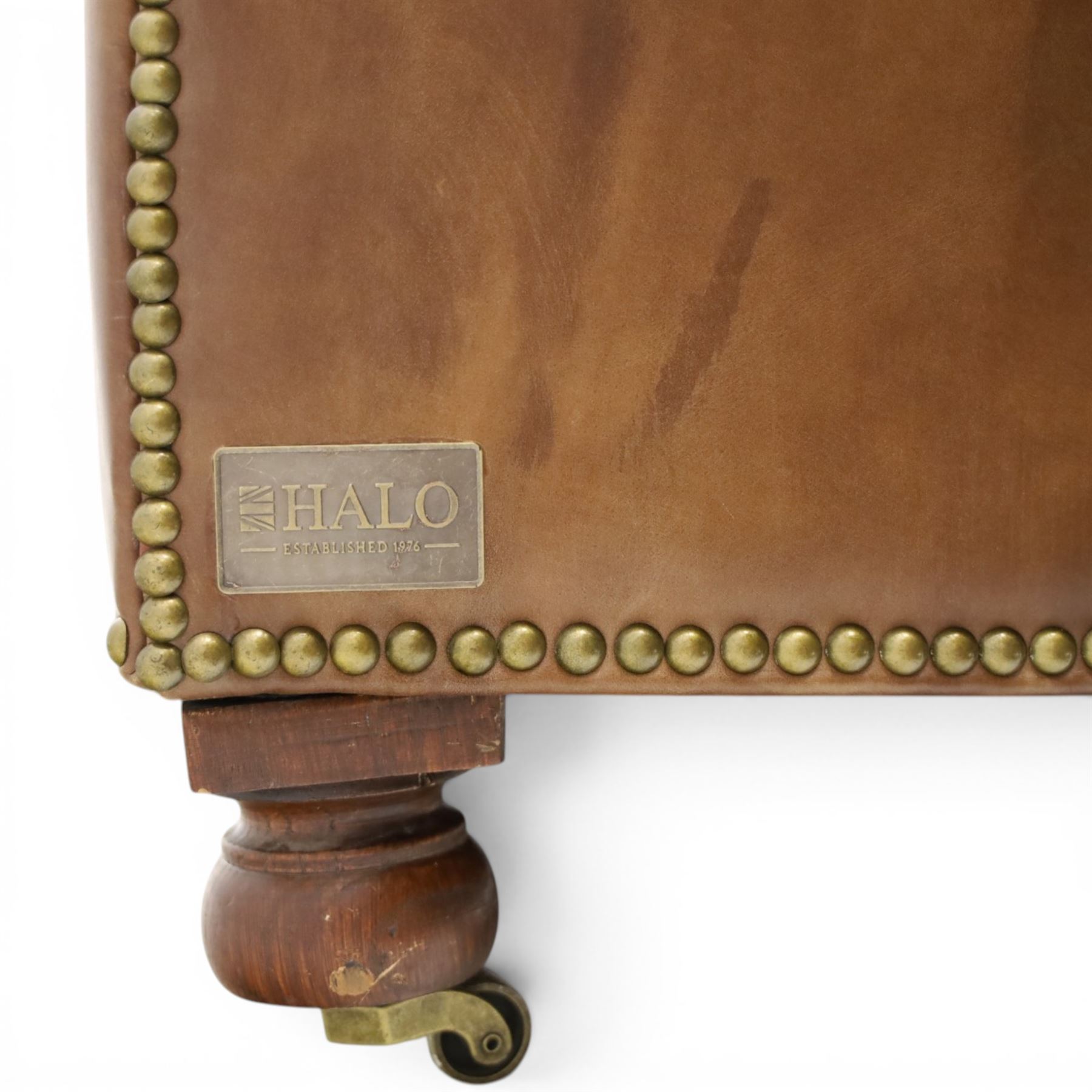 Timothy Oulton for HALO - Three seater brown leather chesterfield sofa, with button back and arms, with two loose cushions, raised on a dark stained supports terminating in castors 