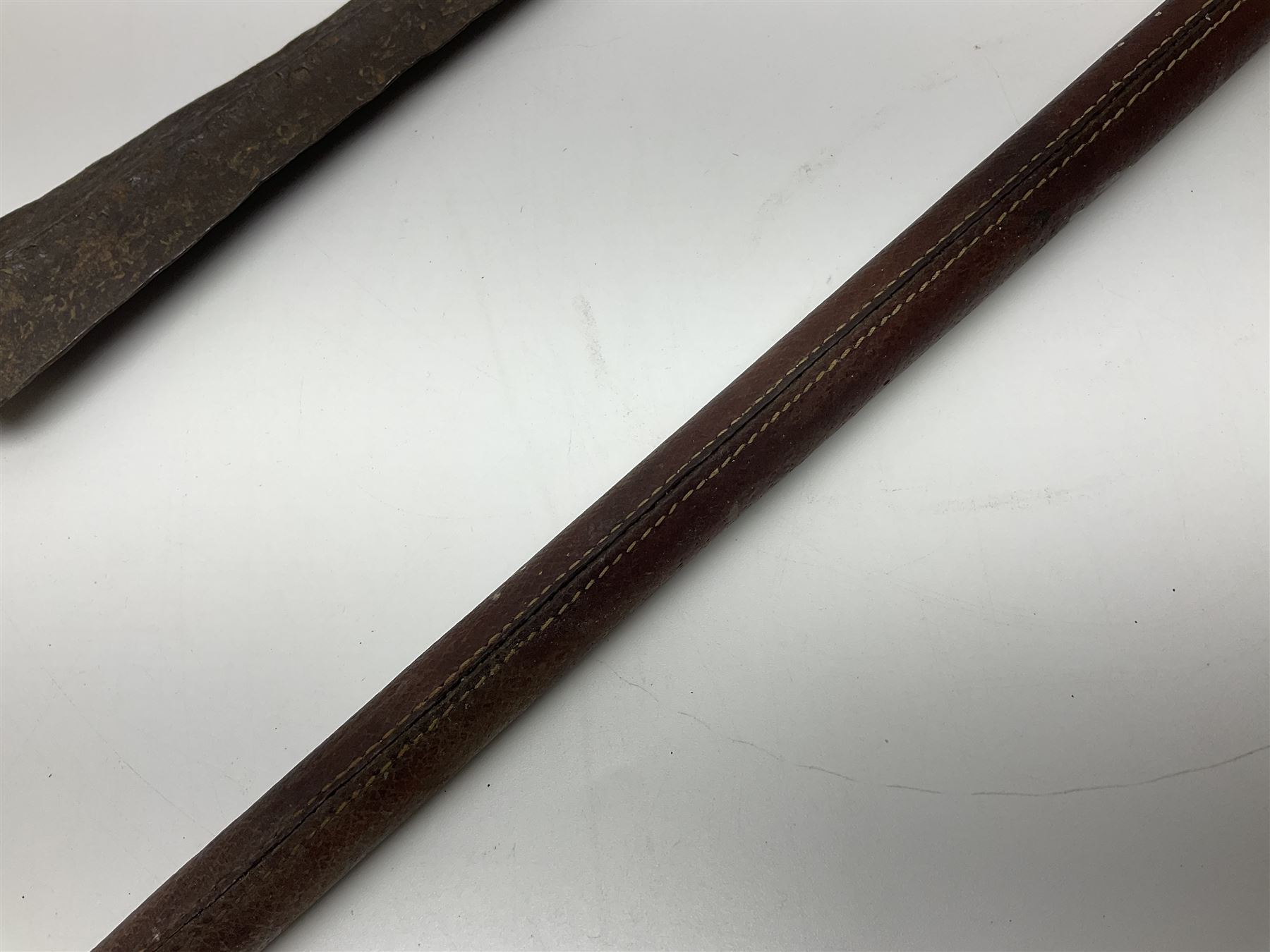 19th century continental folding knife with 15.5cm single edged blade, the pierced brass and iron handle with remains of horn grips L21.5cm overall closed; turned horn handled knife with foliate engraved blade; battlefield relic German 1884/98 knife bayonet; iron spear head; leather covered swagger stick; and two-piece gun cleaning rod