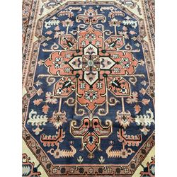 Persian ivory and peach ground, overall geometric design, the field with central star medallion surround stylised leaf motifs, guarded geometric design border