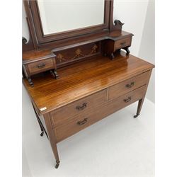 Edwardian inlaid mahogany dressing chest, raised bevelled rectangular mirror above small trinket drawers, the chest fitted with two short and one long drawer, square tapering supports terminating at brass castors