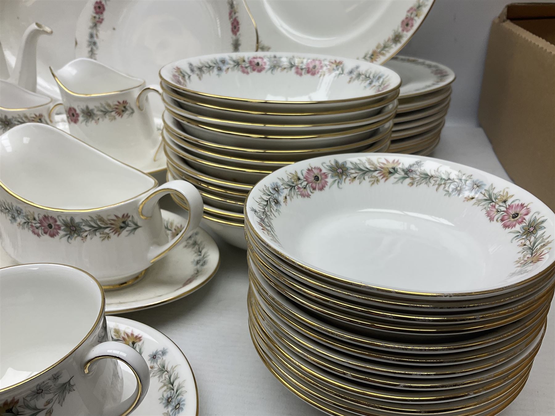 Royal Albert Paragon tea and dinner service for twelve decorated in the Belinda pattern, comprising fourteen saucers, twelve teacups, thirteen side plates, teapot, sauce boat and stand, salt and pepper shakers, two jugs, sucrier, twelve dinner plates, twelve smaller plates, two lidded tureens, twelve bowls, twelve smaller bowls, cake plate, oval plate and oval dish (100)