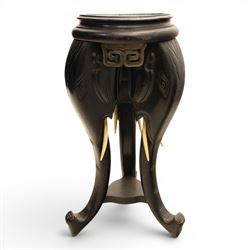 Oriental design black lacquered jardinière stand, circular moulded top with raised rim, the base formed as three elephant heads with carved ears and simulated tusks, on shaped supports with paw terminals