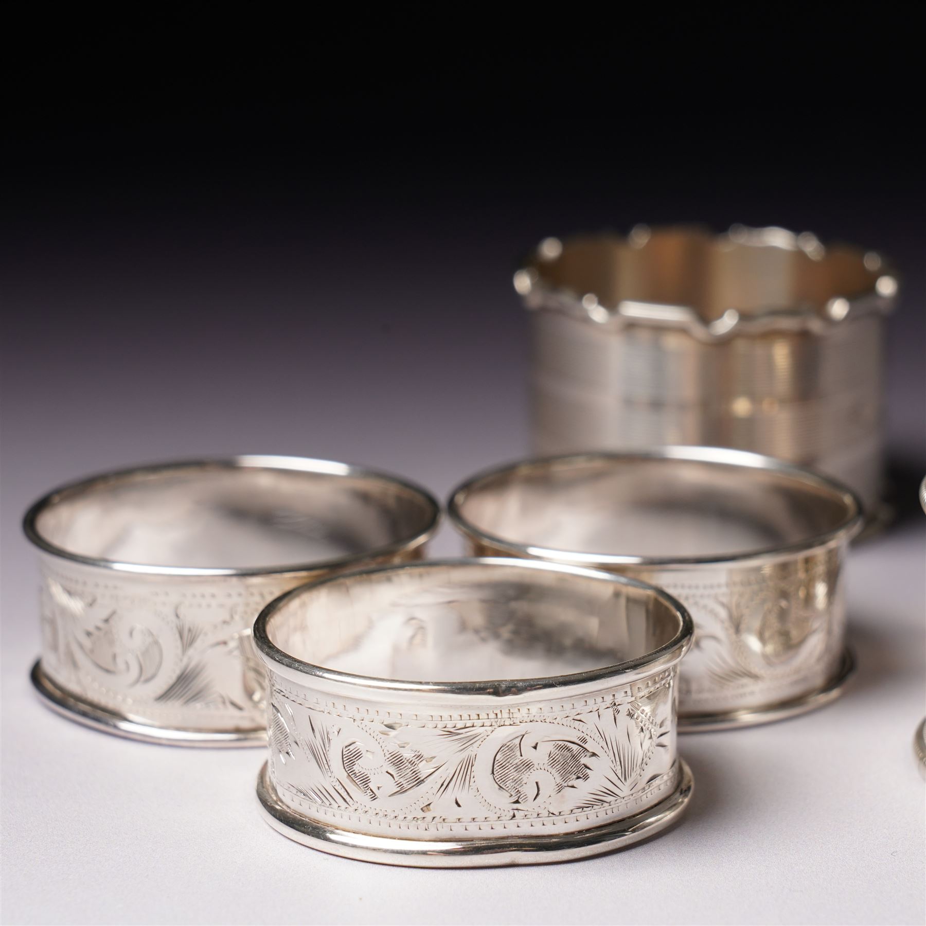 Three engraved silver napkin rings and four others (7)