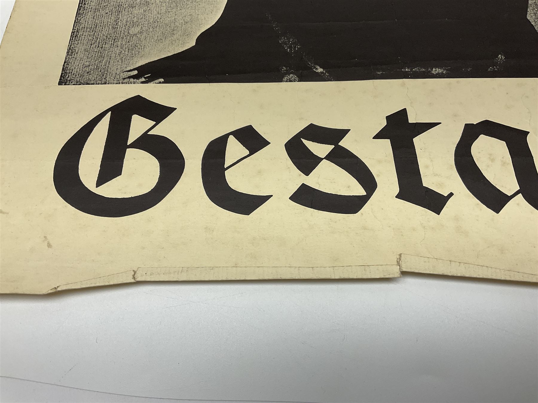 German monochrome 'Gestapo' poster, probably post-WW2, depicting the head of a grim faced Gestapo officer in uniform 55 x 42cm; unframed