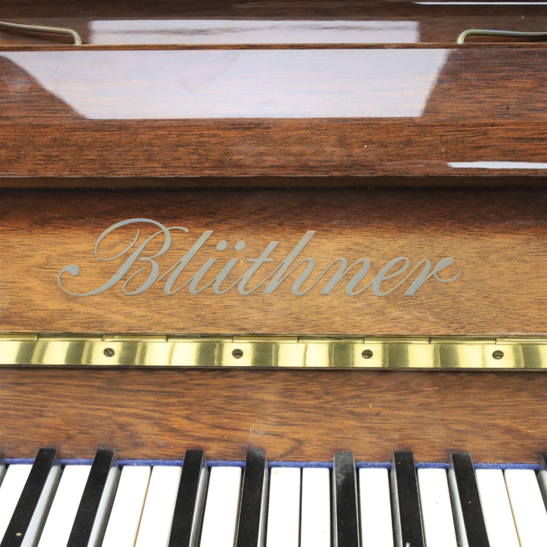 Bluthner of Leipzig upright piano, mahogany case with 88 keys and three brass pedals