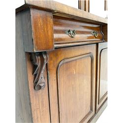 Victorian mahogany bookcase on cupboard, projecting cornice over two glazed doors and carved corbels, fitted with two drawers and double cupboard, plinth base
