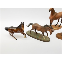 Four Royal Doulton horse figurines, comprising Red Rum, Arkle, and the Winner DA154, and another modelled as a prancing bay horse, largest H32cm. (4). 