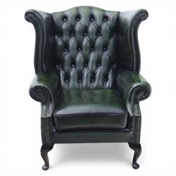 Late 20th century green leather chesterfield style wingback armchair, with deep buttoned back, scrolled wings and arms with studded borders, loose seat cushion, raised on cabriole legs