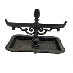 Black painted cast iron boot scraper with handle, decorated with scroll work with shaped tray 