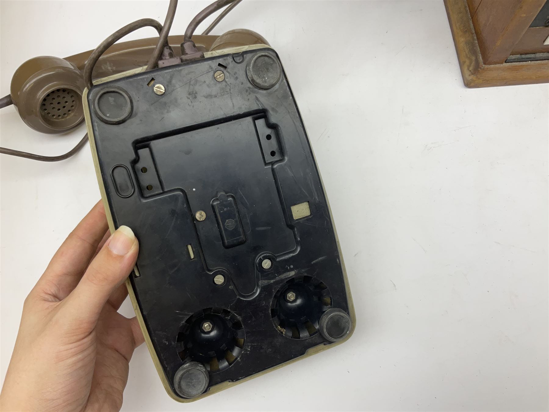 Early-mid 20th century internal telephone system, comprising exchange box with attached TMC rotary telephone and dictograph with Bakelite handset and support upon stained wood case, and 1960s black Bakelite telephone model 312L with G.P.O sticker beneath, largest H30.5cm W36.5cm D30cm