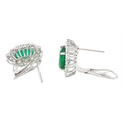 Pair of 18ct white gold emerald and diamond cluster earrings, each stud set with a single oval cut emerald, surrounded by thirteen round brilliant cut diamonds, stamped, total emerald weight approx 7.20 carat, total diamond weight approx 2.30 carat