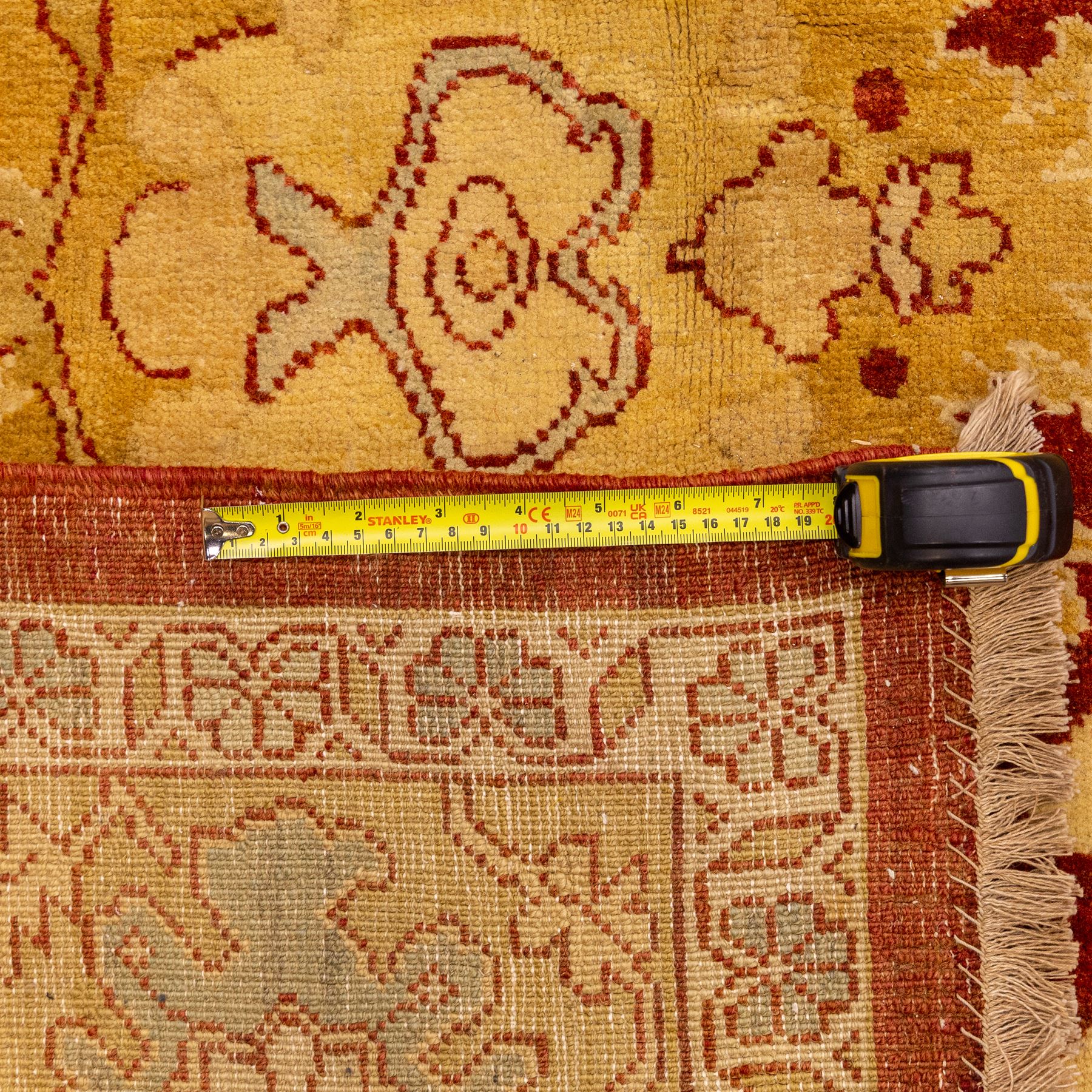 Central Persian Ziegler design hand-woven carpet, rich madder red field with central stylized lozenge medallion enclosed with an all-over lattice of scrolling vine, palmettes, and angular floral motifs of the Sultanbad tradition, broad ivory main border decorated with large-scale rosettes and flowering cartouches, flanked by narrow guard stripes, with fringe ends 