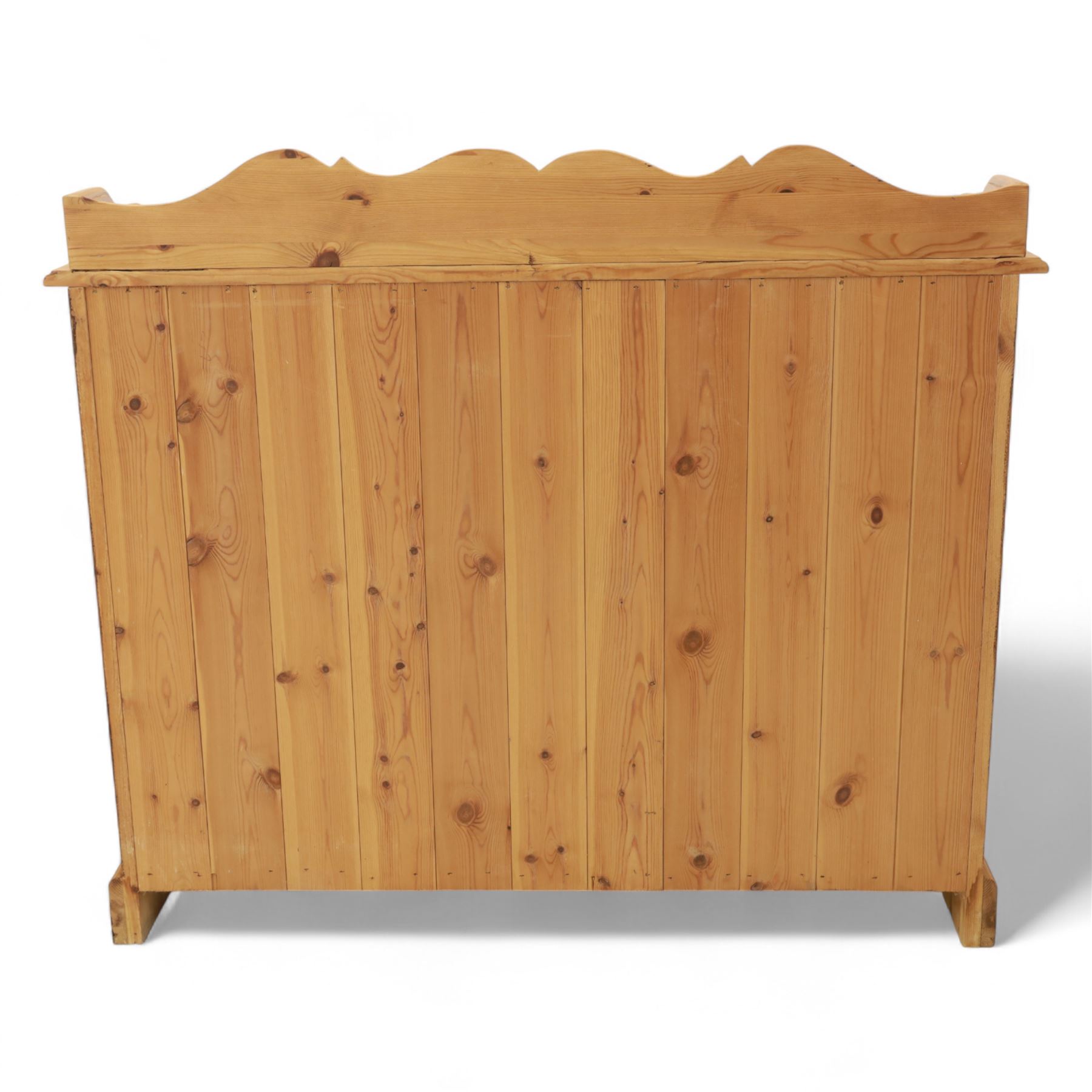 Contemporary pine cupboard, with raised shaped gallery over plain top, panelled double doors below with turned knob handles, shaped apron and plinth base
