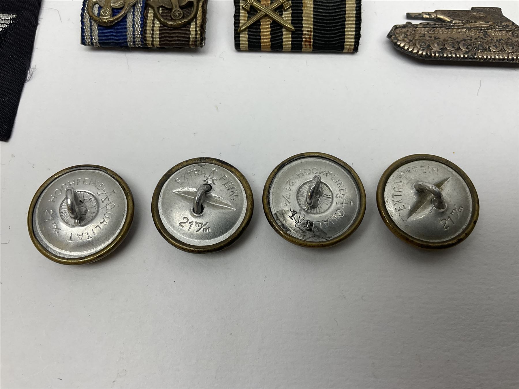 Collection of eleven German metal and cloth badges and uniform buttons including driver's badge, two 'SS' fabric skulls, private's shoulder tabs, Police cloth badge, tank destruction badge, medal bars and ribbon etc; most WW2 period